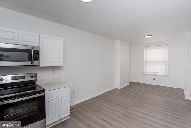 kitchen featuring white cabinets, light hardwood / wood-style floors, and stainless steel appliances