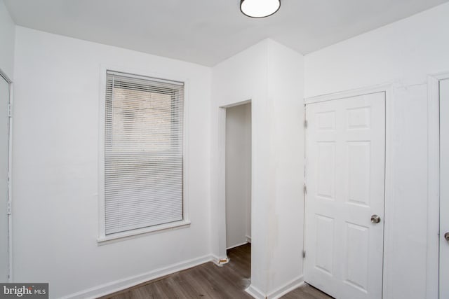 unfurnished bedroom featuring a closet and dark hardwood / wood-style floors