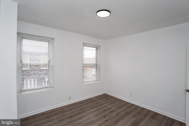 unfurnished room with dark hardwood / wood-style flooring