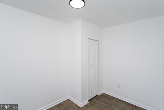 unfurnished room featuring dark wood-type flooring