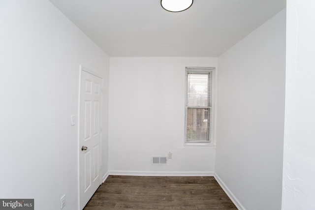 unfurnished room with dark wood-type flooring