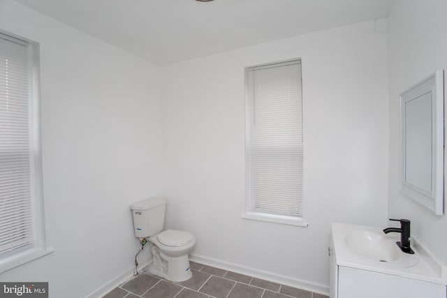 bathroom featuring tile patterned flooring, vanity, and toilet