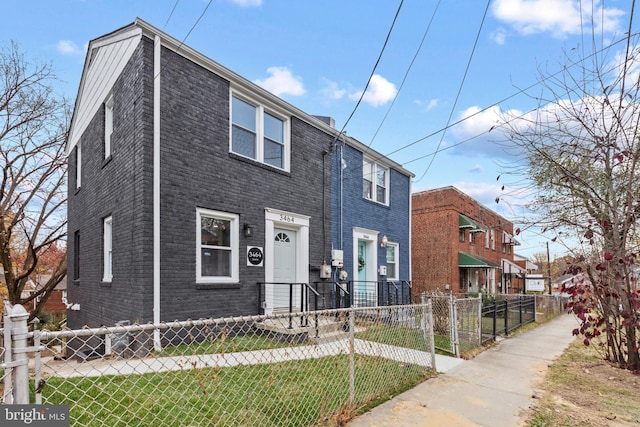 townhome / multi-family property featuring a front lawn