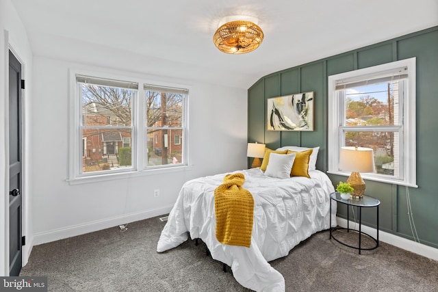 bedroom with dark carpet and multiple windows