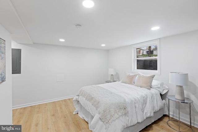 bedroom with electric panel and wood-type flooring