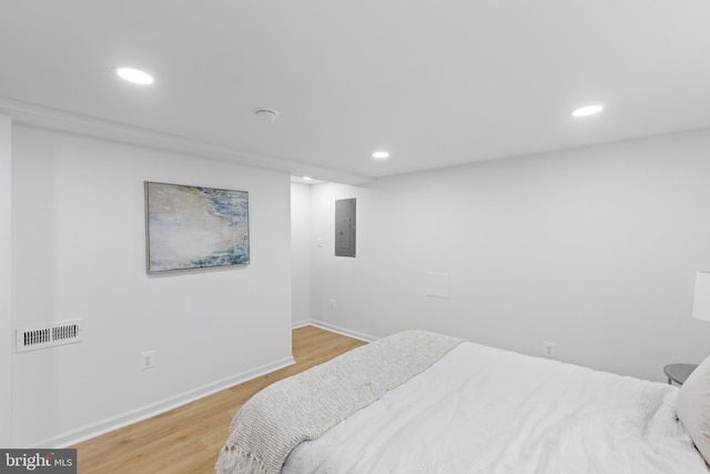 bedroom with light wood-type flooring and electric panel