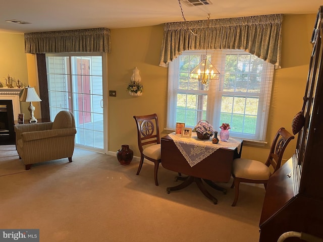 carpeted dining room with a wealth of natural light and a chandelier