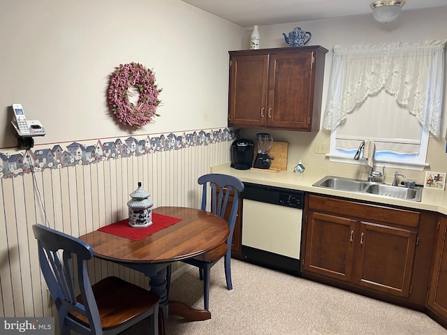 kitchen with dark brown cabinetry, dishwasher, light colored carpet, and sink