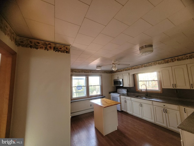 kitchen with ceiling fan, sink, dark wood-type flooring, white electric stove, and a kitchen island