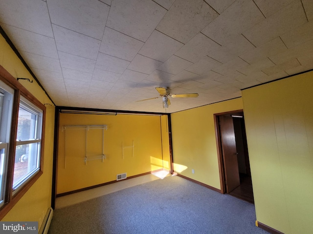 carpeted spare room featuring ceiling fan and baseboard heating