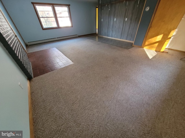 unfurnished room with carpet flooring and a baseboard heating unit