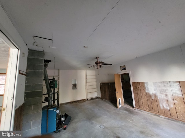 basement with wooden walls and ceiling fan