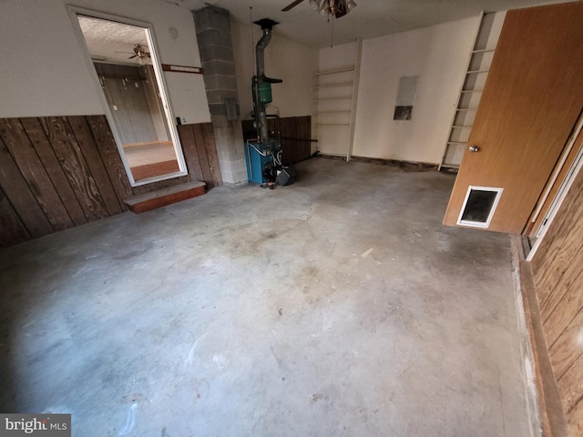 interior space featuring ceiling fan and wood walls