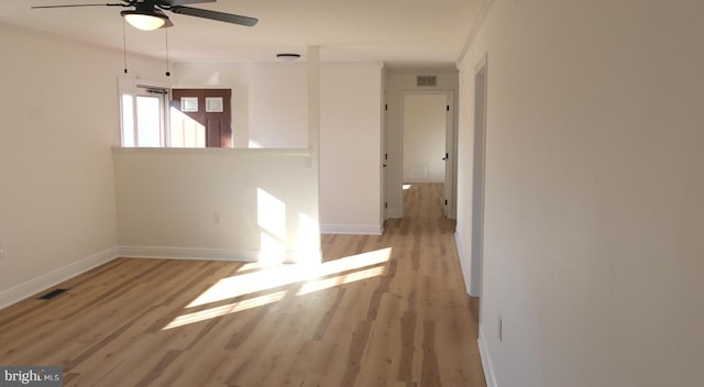 unfurnished room with ceiling fan, wood finished floors, visible vents, and baseboards