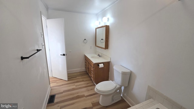 bathroom featuring crown molding, visible vents, toilet, vanity, and wood finished floors