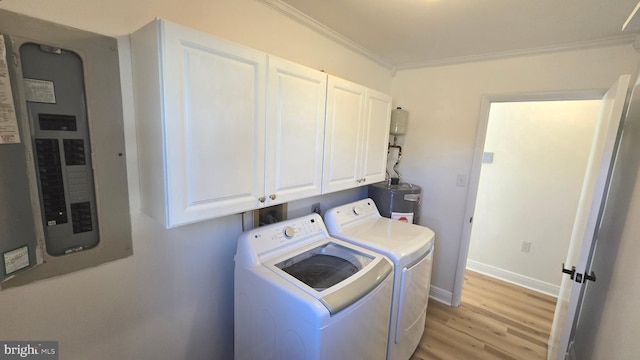 laundry room with cabinet space, light wood finished floors, electric panel, washer and clothes dryer, and crown molding