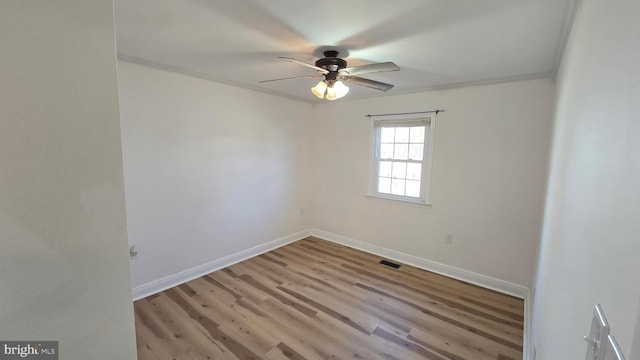 empty room with light wood finished floors, baseboards, visible vents, and ceiling fan