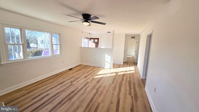 interior space with ceiling fan, light wood-type flooring, visible vents, and baseboards