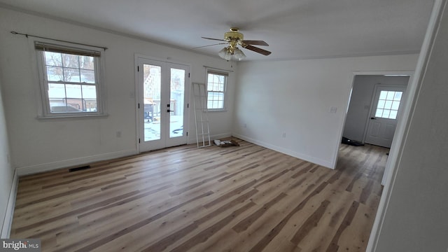 foyer entrance featuring visible vents, baseboards, and wood finished floors