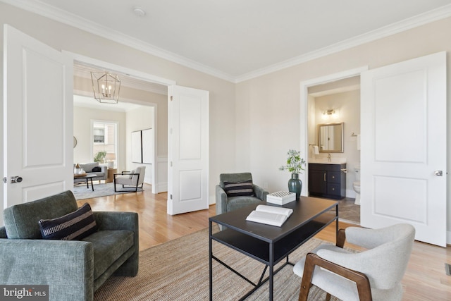 living room featuring crown molding, light hardwood / wood-style flooring, and a notable chandelier