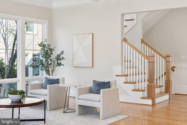 living area featuring crown molding and light hardwood / wood-style floors