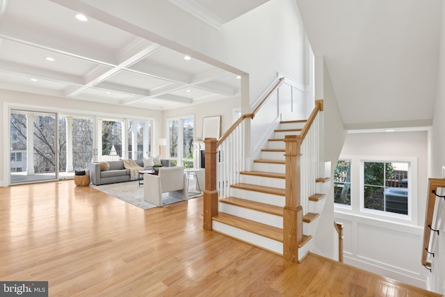 stairway featuring hardwood / wood-style flooring, coffered ceiling, and beamed ceiling