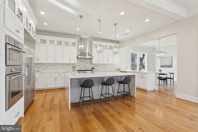 kitchen featuring white cabinetry, a kitchen island with sink, pendant lighting, and a breakfast bar