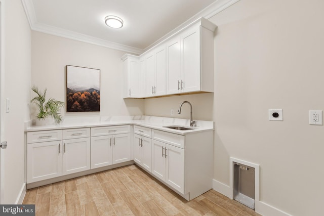 laundry room featuring cabinets, electric dryer hookup, sink, and light wood-type flooring