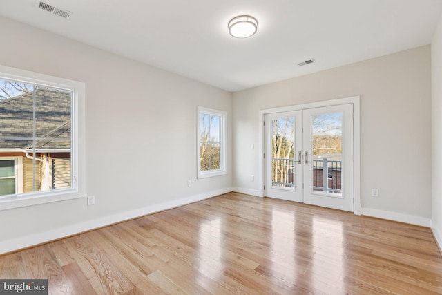 empty room featuring light wood-type flooring and french doors