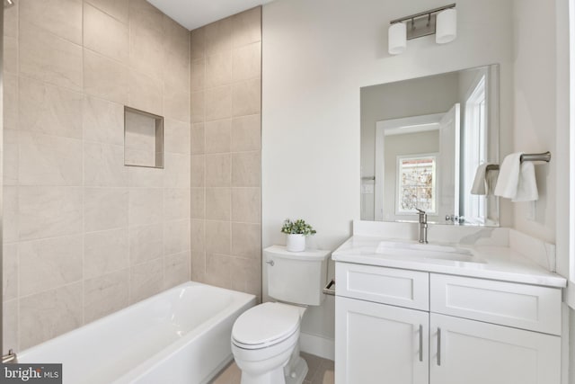 full bathroom featuring vanity, tiled shower / bath combo, and toilet