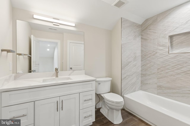 full bathroom featuring vanity, tiled shower / bath combo, and toilet