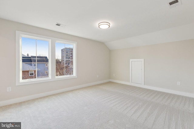 bonus room with vaulted ceiling and carpet flooring