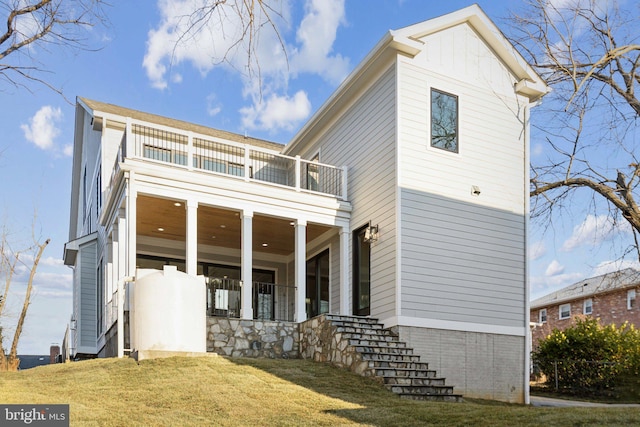 front facade featuring a balcony and a front lawn