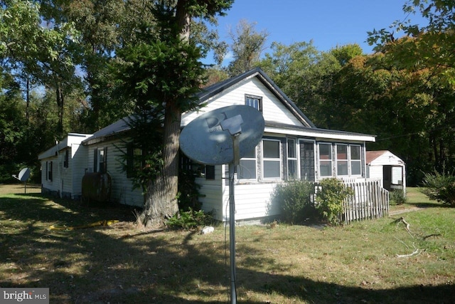 view of side of property with a lawn and a sunroom