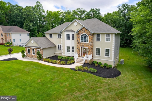 colonial house with a front yard and central air condition unit