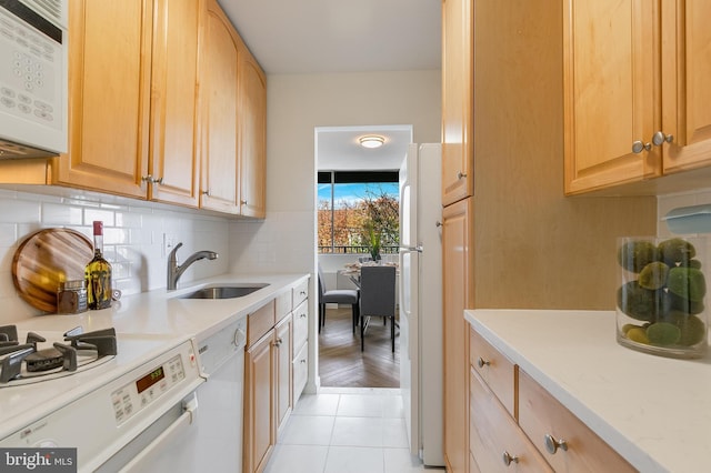 kitchen featuring decorative backsplash, white appliances, sink, light brown cabinets, and light hardwood / wood-style flooring