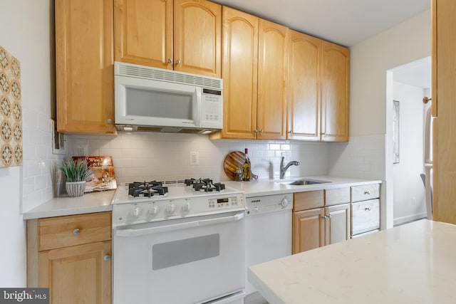 kitchen with light brown cabinets, white appliances, sink, and tasteful backsplash