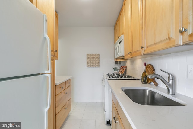 kitchen featuring decorative backsplash, light brown cabinetry, white appliances, sink, and light tile patterned floors