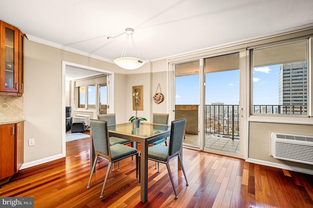 dining space featuring hardwood / wood-style flooring, crown molding, and a wall unit AC