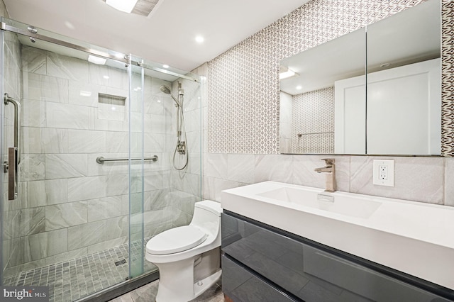 bathroom with walk in shower, vanity, toilet, and tile walls