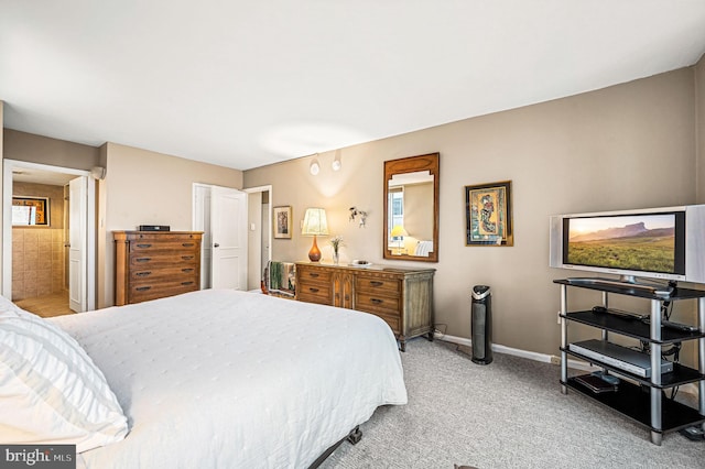 bedroom with light carpet and ensuite bath