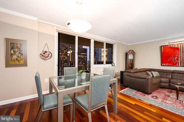 dining area featuring dark wood-type flooring and ornamental molding