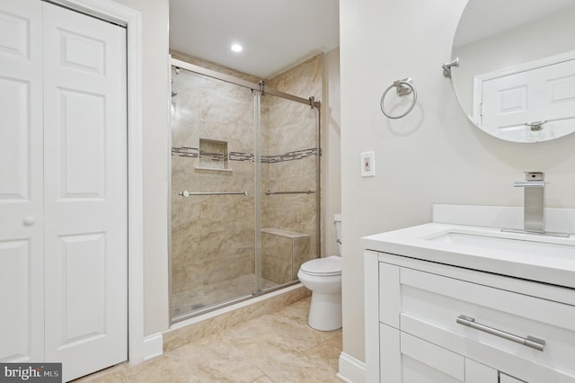 bathroom featuring toilet, vanity, and an enclosed shower