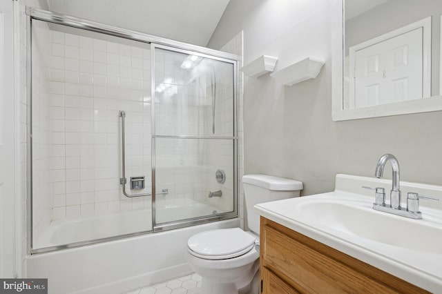 full bathroom featuring toilet, vanity, tile patterned floors, and bath / shower combo with glass door