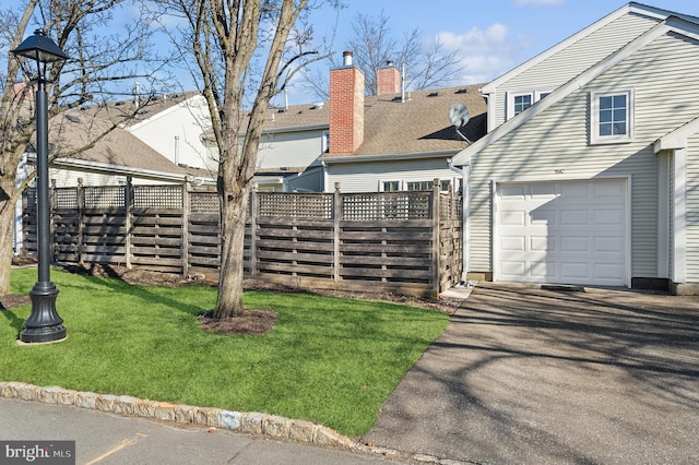 exterior space with a garage and a lawn