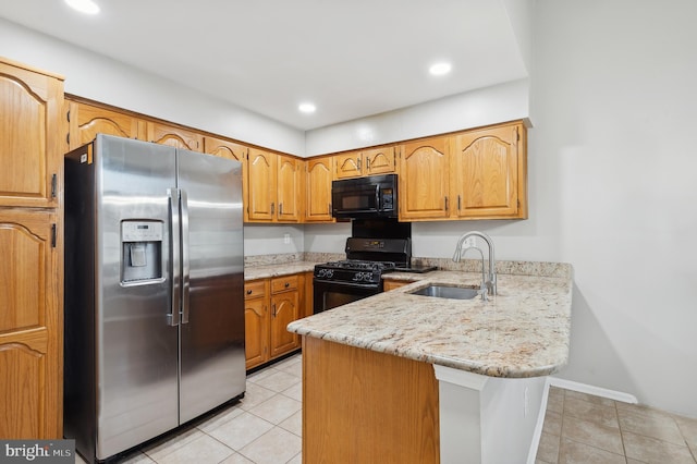 kitchen with light tile patterned floors, kitchen peninsula, black appliances, light stone counters, and sink