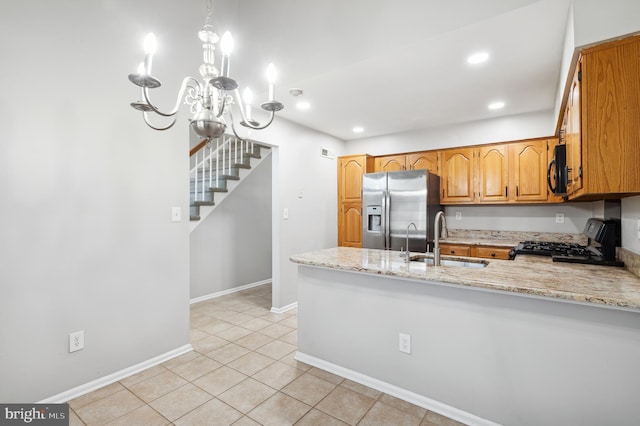 kitchen with stove, kitchen peninsula, stainless steel refrigerator with ice dispenser, sink, and light stone countertops