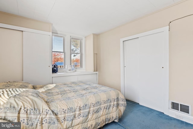 carpeted bedroom featuring ornamental molding and a closet