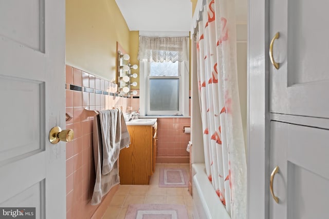 bathroom with tile patterned flooring, vanity, shower / bath combination with curtain, and tile walls