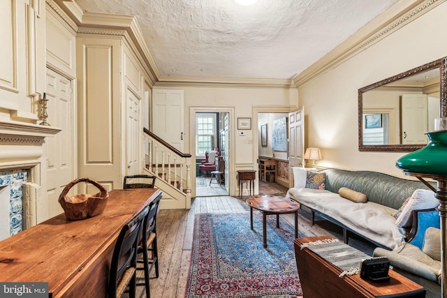 living room with hardwood / wood-style flooring, crown molding, and a textured ceiling